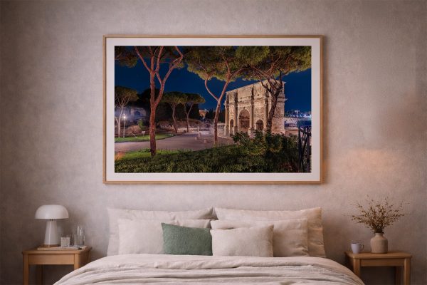 Fotografie eines beleuchteten historischen Steintors mit Bäumen bei Nacht, gerahmt über einem gemütlichen Bett im modernen Schlafzimmer