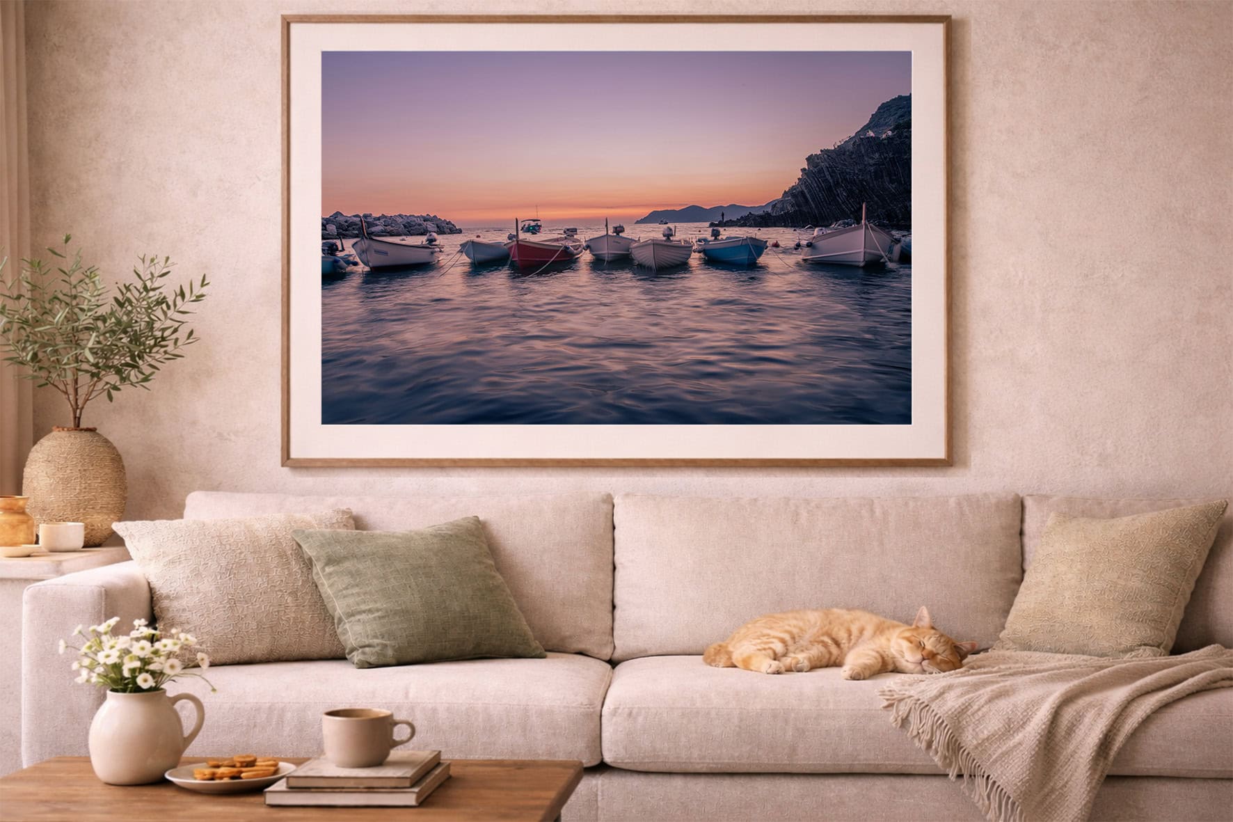 Gerahmtes Foto mit Booten auf ruhigem Wasser bei Sonnenuntergang über beiger Sofa-Landschaft im Wohnzimmer