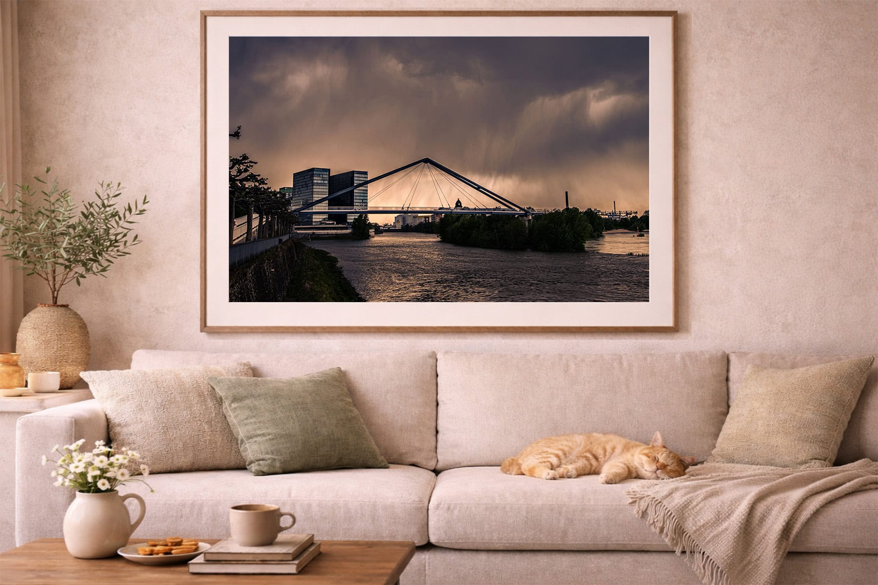 Fotografie einer modernen Brücke über einem Fluss bei dramatischem Abendhimmel in großem Rahmen über beigefarbenem Sofa