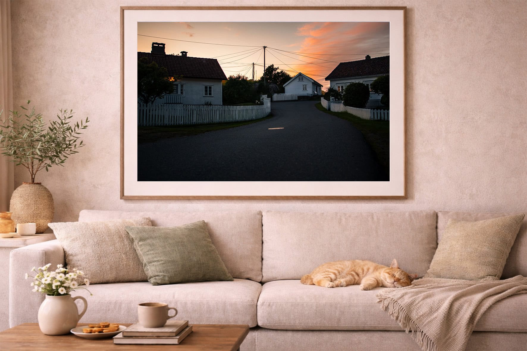 Fotografie einer ruhigen Dorfstraße bei Sonnenuntergang in großem Rahmen über beiger Sofa-Landschaft mit Kissen