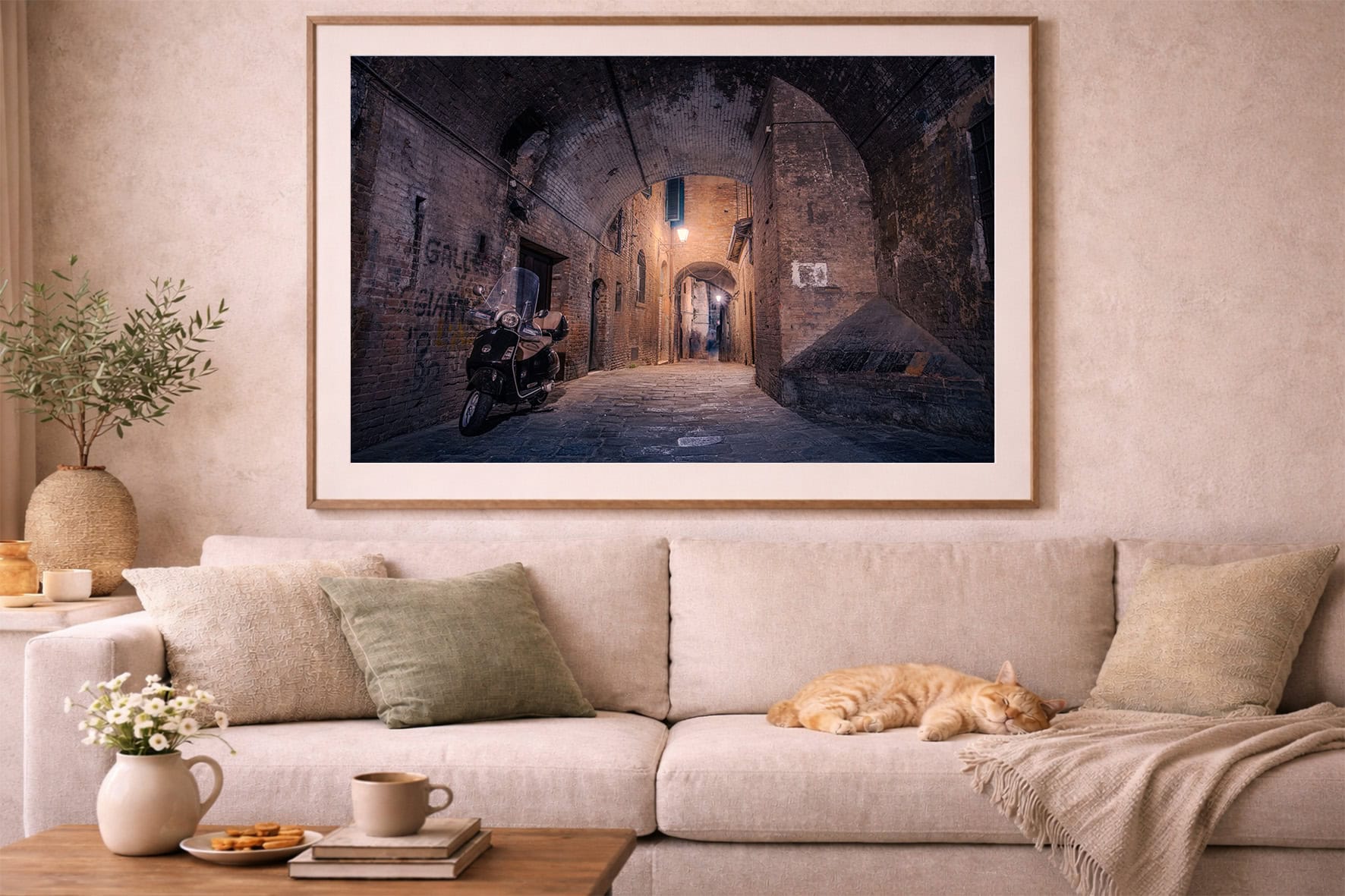 Fotografie einer nächtlichen, engen Backsteingasse mit Motorroller im Bogen, als gerahmtes Wandbild über beiger Sofa-Landschaft.
