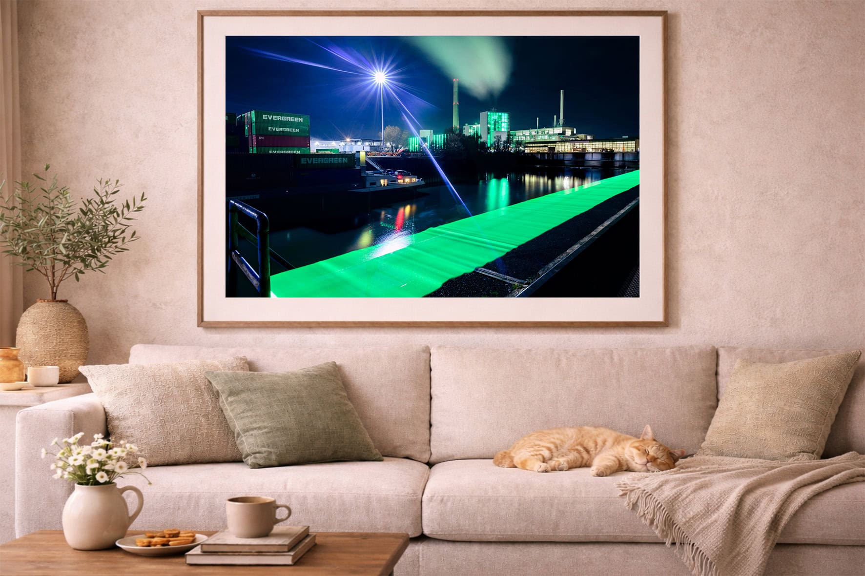 Fotografie eines nächtlichen Industriehafens mit grüner Lichtbrücke über dem Wasser in einem hellen Wohnzimmer über einem Sofa