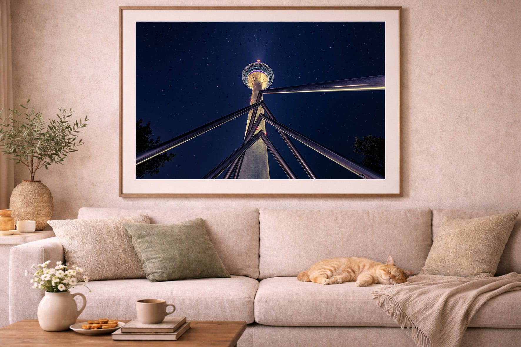 Fotografie eines beleuchteten Turms mit Stahlträgern vor Sternenhimmel in großem Rahmen über beiger Wohnzimmer-Couch
