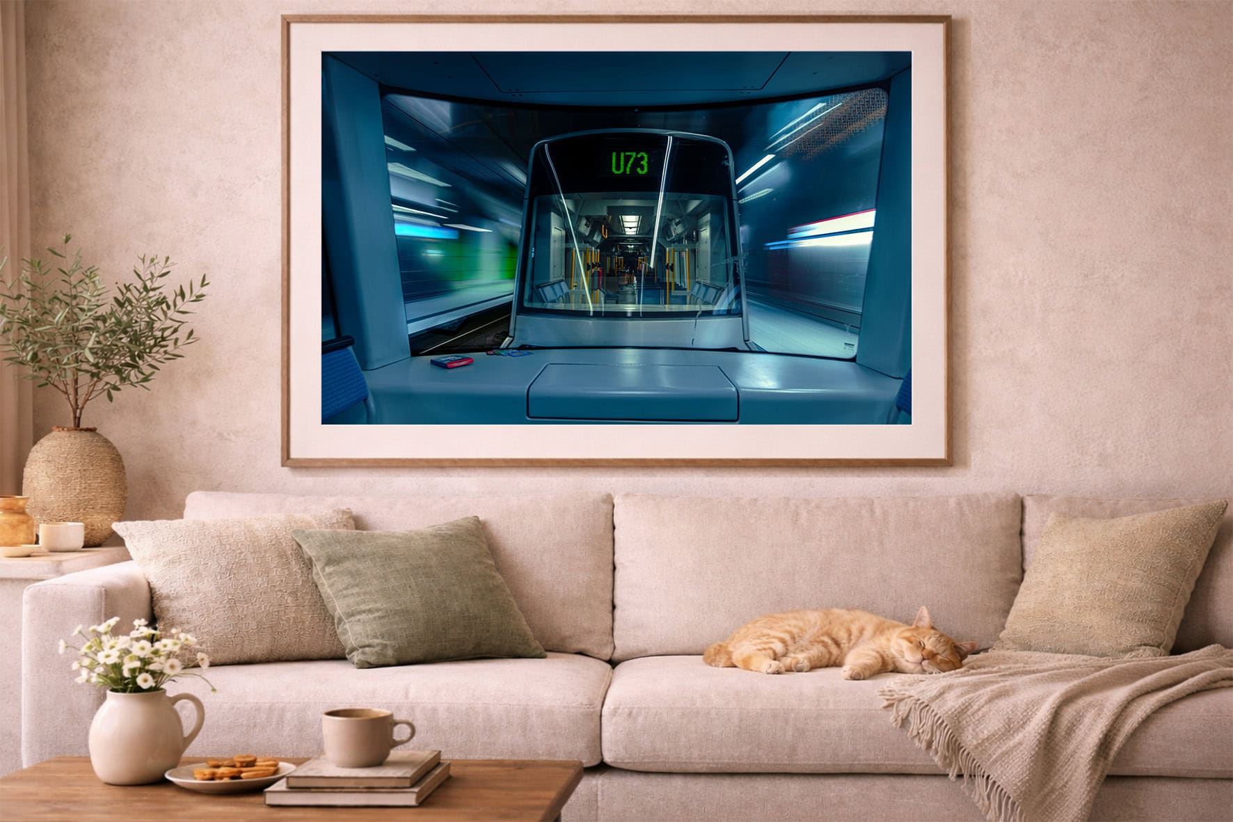 Fotografie einer fahrenden U-Bahn mit Anzeige U73 im Holzrahmen über beigefarbenem Sofa mit schlafender Katze.