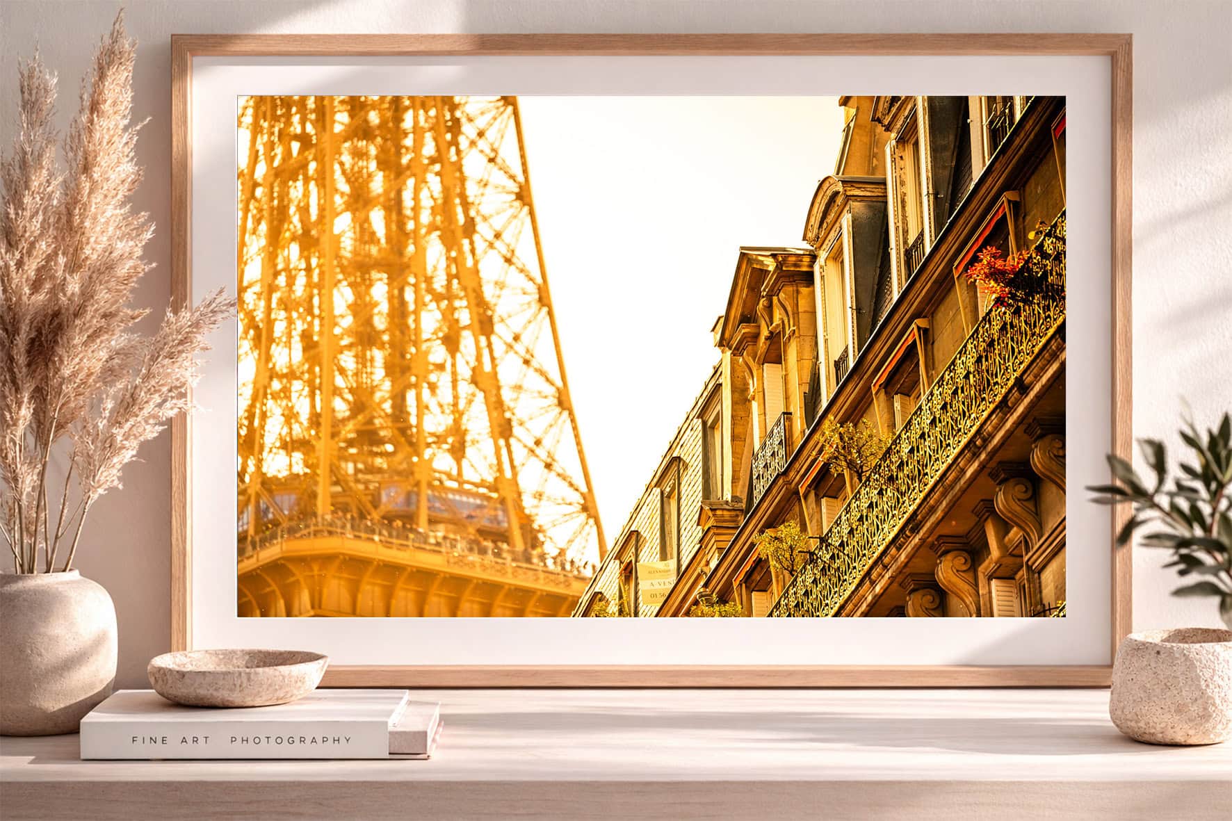Fotografie mit golden beleuchtetem Stahlturm und klassischer Hausfassade im Holzrahmen auf Sideboard