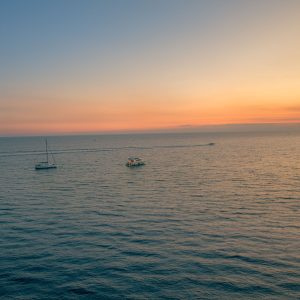 Ruhige Meeresfläche bei Manarola mit zwei Booten unter orange-blauem Abendhimmel