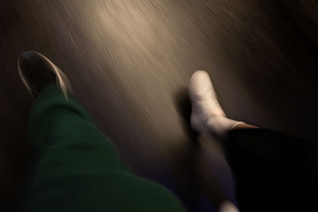 Bewegte Schritte von zwei Personen auf dunklem Boden, inspiriert von der Paris Metro in Langzeitbelichtung