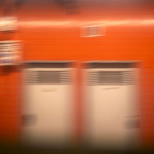 Orange Metrostation Gabriel Péri in Paris mit Bewegungsunschärfe und zwei hellen Türen