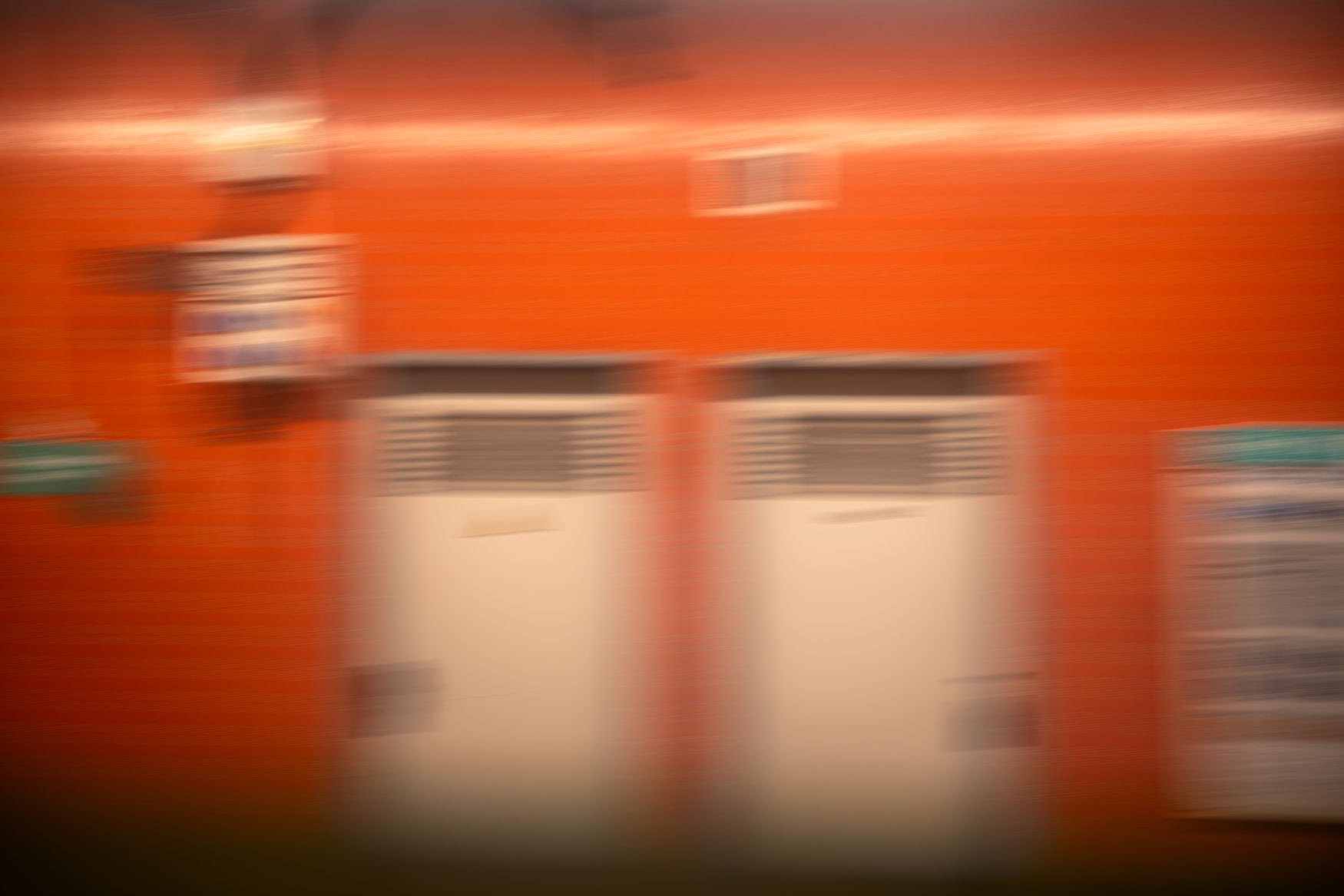 Orange Metrostation Gabriel Péri in Paris mit Bewegungsunschärfe und zwei hellen Türen