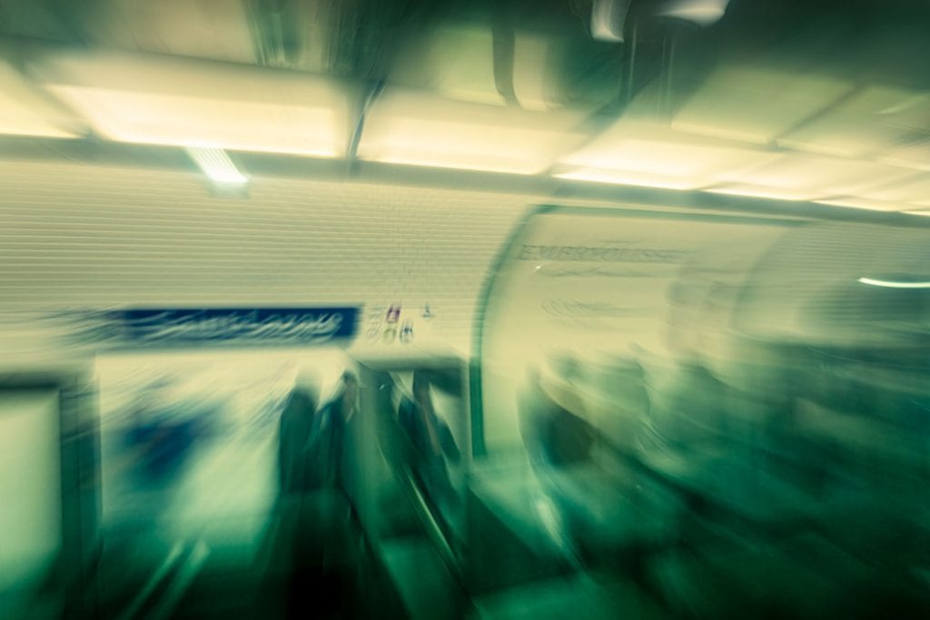 Bewegungsunscharfe Szene in der Paris Metro Saint-Lazare mit Zug, Bahnsteig und schemenhaften Menschen