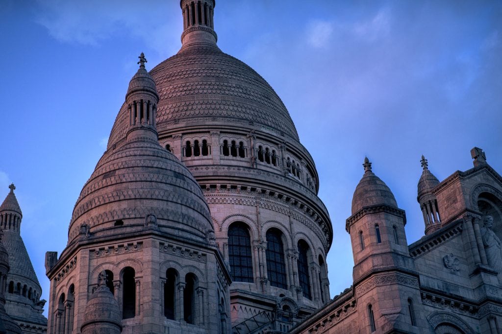 Kuppeln der Basilika Sacré-Cœur in Paris vor blauem Abendhimmel