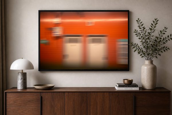 Großes abstraktes Wandbild mit unscharfer orangefarbener Bahnhofsszene über einem modernen Sideboard im Wohnzimmer