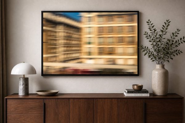 Großer gerahmter Kunstdruck mit unscharfer Stadtfassade über einem modernen Holz-Sideboard im eleganten Wohnzimmer