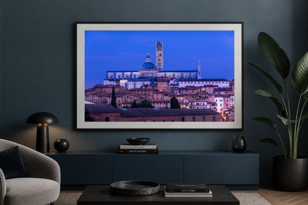Fotografie einer historischen Stadt mit Kathedrale im blauen Abendhimmel, gerahmt über einem modernen Lowboard im Wohnzimmer.