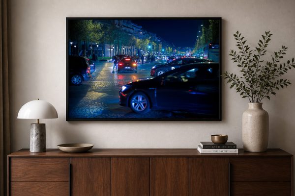 Fotografie einer belebten Stadtstraße bei Nacht mit Autoscheinwerfern, gerahmt über Sideboard mit Lampe, Büchern und Vase