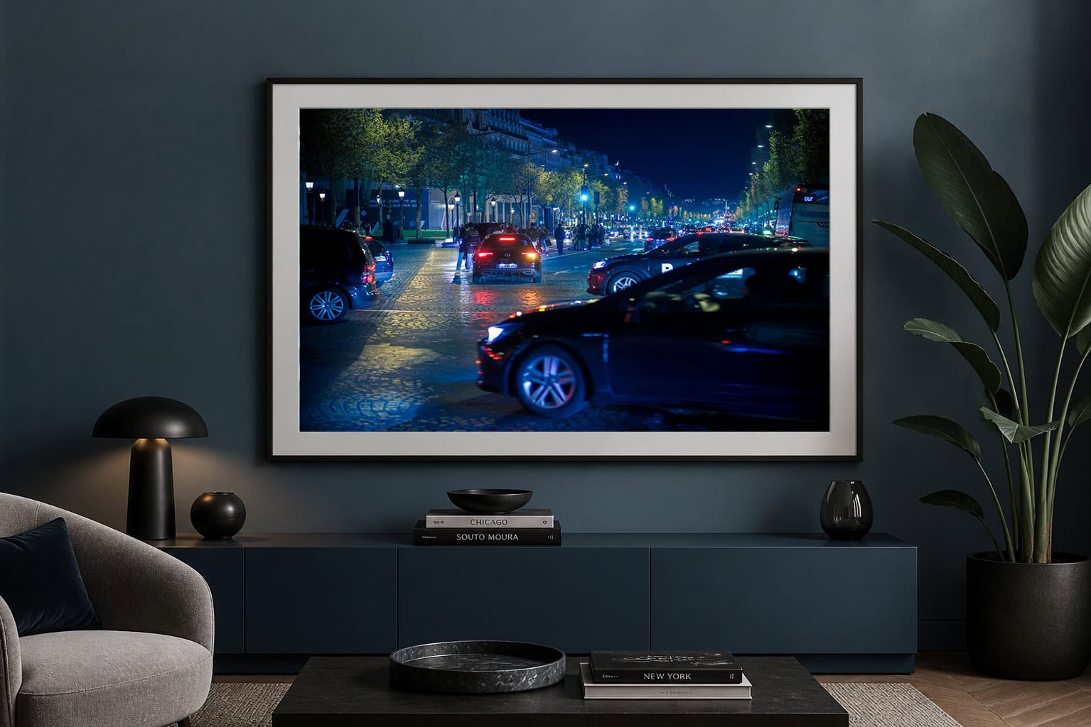 Fotografie einer belebten Stadtstraße bei Nacht mit Autos und blauem Licht, gerahmt über einem dunklen Sideboard in modernem Wohnzimmer