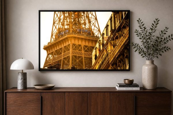 Fotografie eines Turm- und Fassadendetails in goldenem Licht über einem Sideboard im modernen Wohnraum
