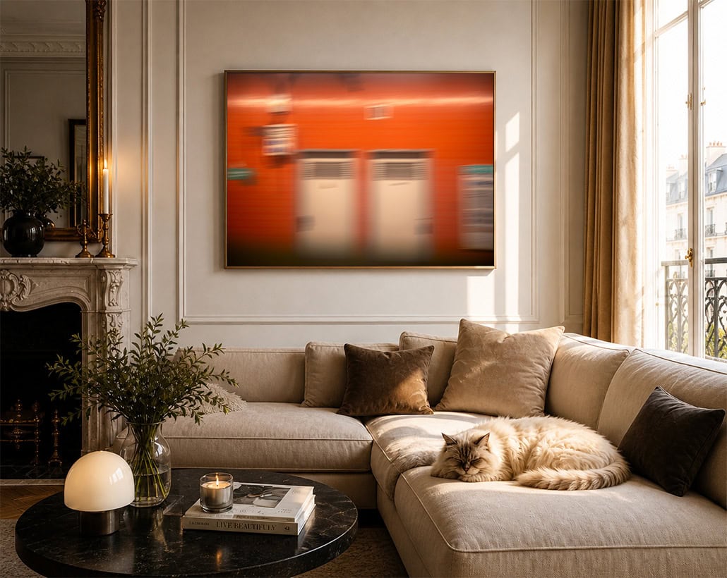 Großes abstraktes Wandbild mit roter, unscharfer Fassade über beigem Sofa in elegantem Wohnzimmer mit Katze