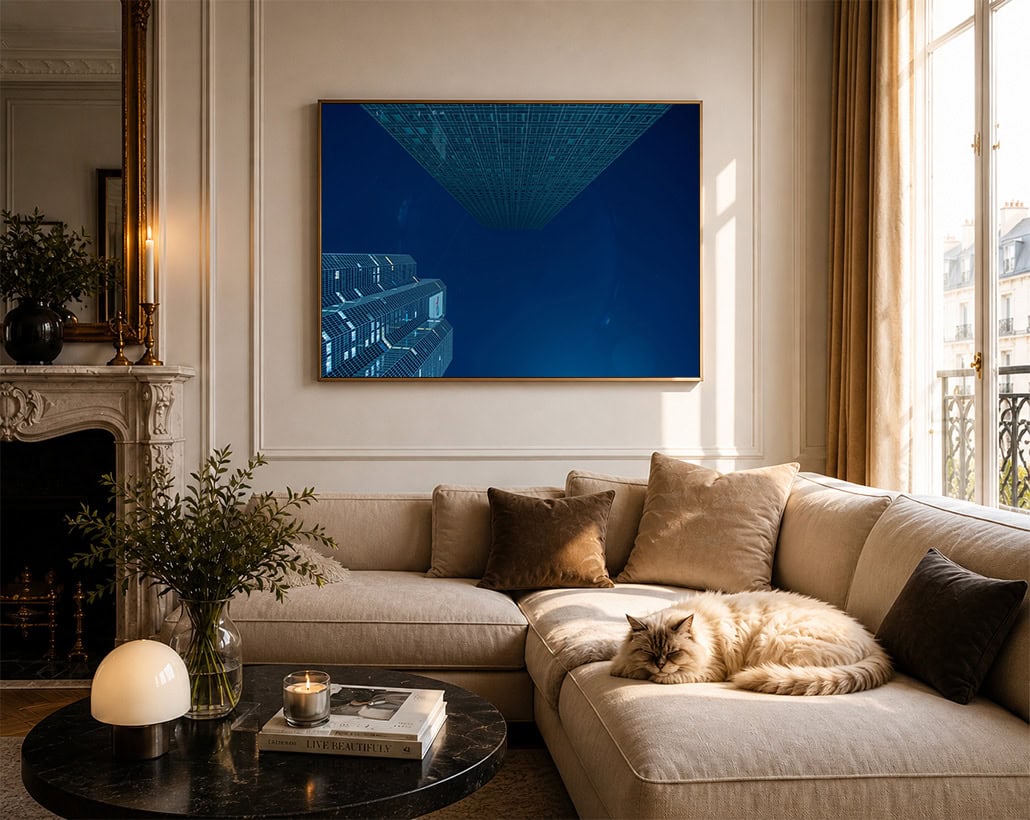 Fotokunst mit blauen Hochhäusern bei Nacht über beigem Ecksofa in elegantem Wohnzimmer mit Kamin und großem Fenster