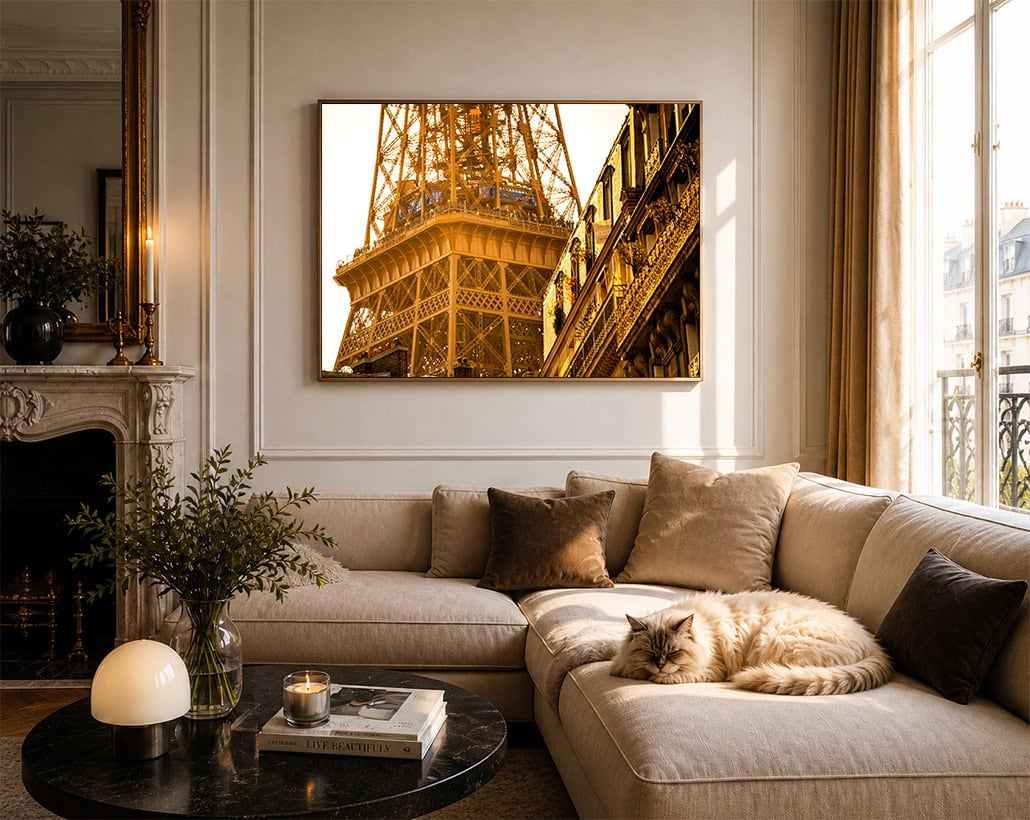 Fotografie eines goldgelb beleuchteten Stahlbaus und Fassadendetails über einem Sofa in einem hellen Wohnzimmer