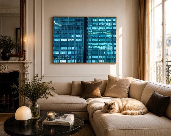 Fotokunst mit blauen Glasfassaden von Hochhäusern über einem beigen Sofa in elegantem Wohnzimmer mit Katze