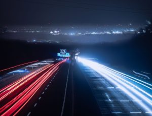 Nachtaufnahme der A46 mit Lichtspuren der Autos und Blick auf Düsseldorf